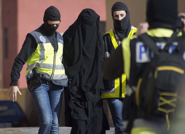 Policías trasladan a una detenida por yihadismo en Melilla en diciembre de 2014. :: Jesús blasco/Reuters.
