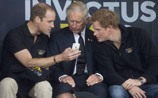 Los príncipes de Inglaterra William (i.) y Harry (d.), con su padre.