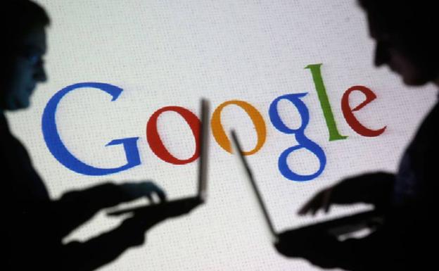 Dos personas delante del logotipo de Google.