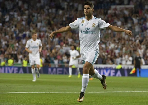 Marco Asensio celebra uno de los dos goles que le marcó ayer al Valencia en el estadio Santiago Bernabéu. :: CURTO DE LA TORRE / AFP