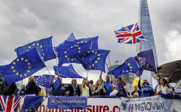 Varias personas con banderas de la Unión Europea protestan contra el 'brexit' en un barco por el río Támesis, en Londres.