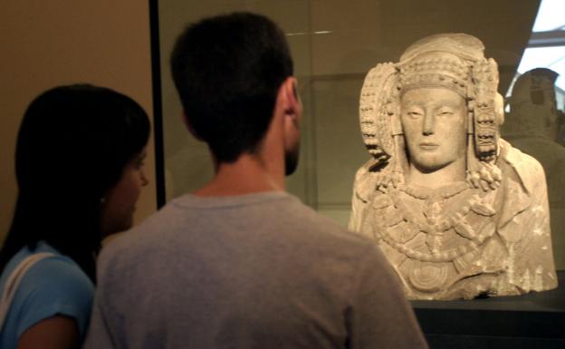 Dos personas observan la Dama de Elche.