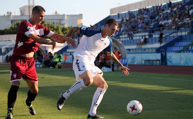 Otín, debutrante, controla el balón ante la vigilancia de un jugador del San Fernando.