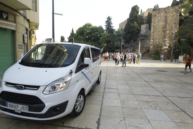 Un taxi de 9 plazas se adentra por la calle Císter, en el Centro de Málaga. 