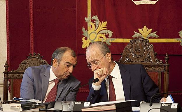 El alcalde hace una consulta al secretario del Ayuntamiento. 