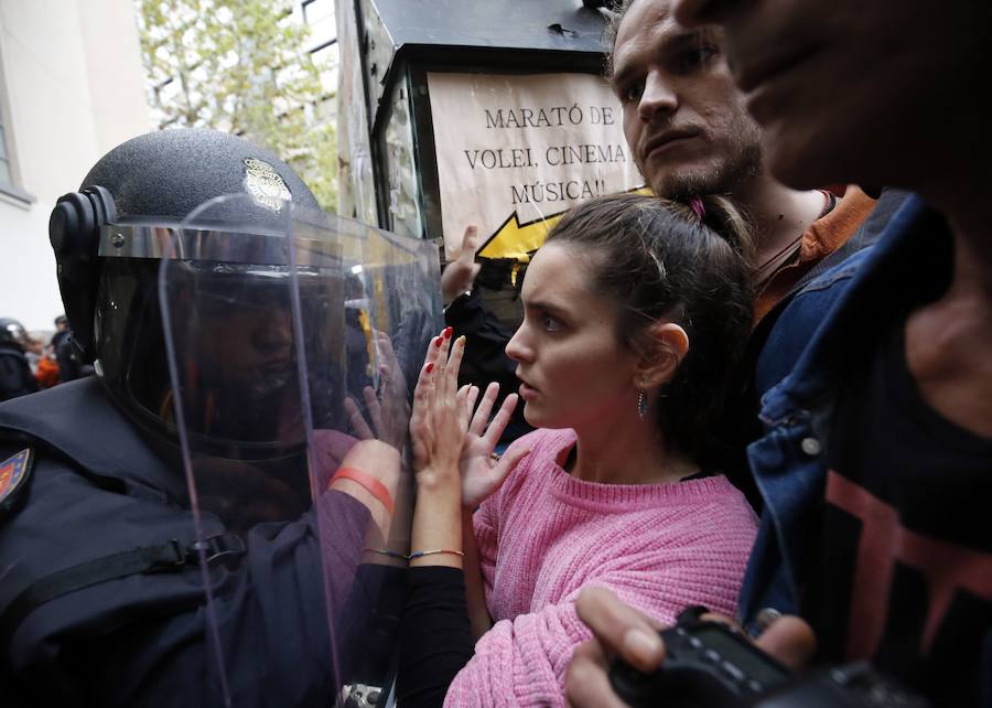 Manifestantes frente a un agente de Policía.