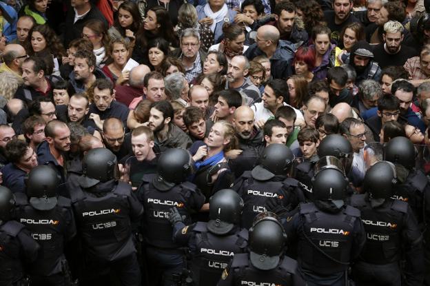 Antidisturbios de la Policía Nacional forman ayer un cordón de seguridad en los alrededores del colegio Ramón Llull de Barcelona. :: alberto estévez / efe
