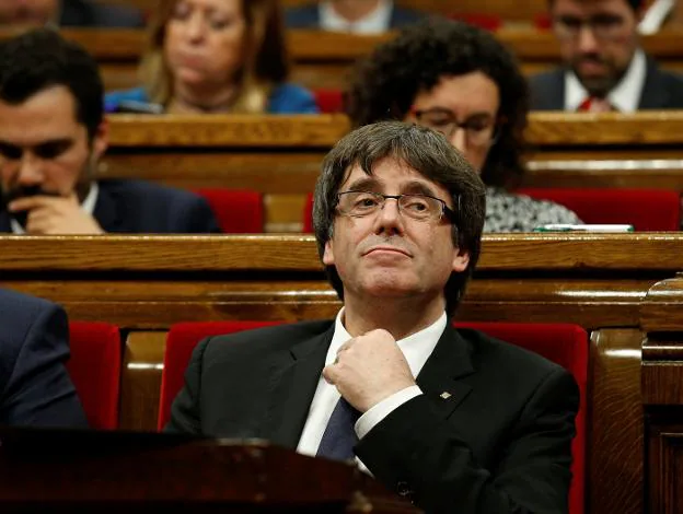 Puigdemont se coloca la corbata durante la sesión. :: a. g. / reuters