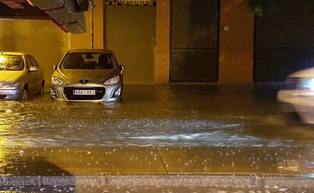 Un coches, en una balsa de agua en la capital.