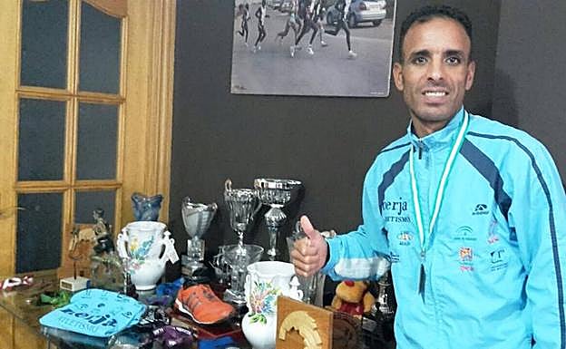 El atleta marroquí del Cueva de Nerja-UMA, ayer en su domicilio de Maracena con varios trofeos