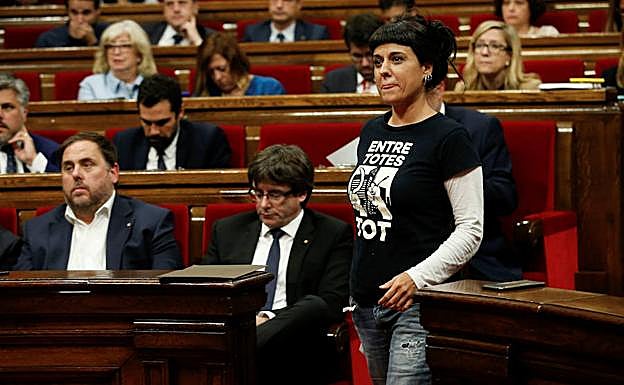 La diputada de la CUP, Anna Gabriel, pasa por delante del escaño de Puigdemont.