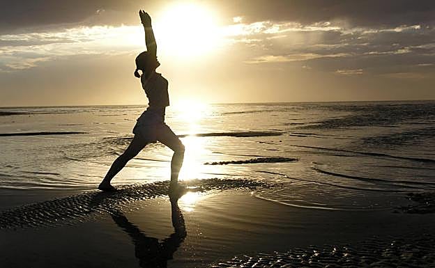 Una nujer hace ejercicio en una playa.
