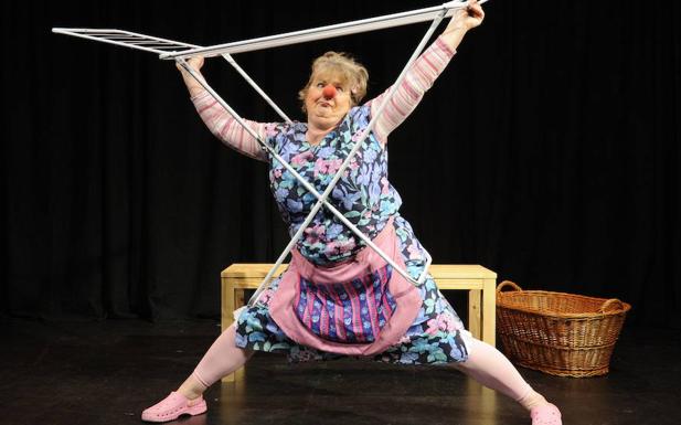 Mujer, caracterizada de payaso, representa una parodia del ama de casa en un teatro de Bremen. 