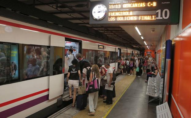 Turistas entran en un tren de Cercanías abarrotado con destino a la Costa del Sol.