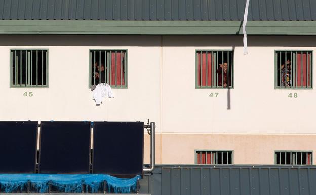 Varios inmigrantes trasladados asomados a las ventanas de la futura cárcel de Archidona (archivo). 