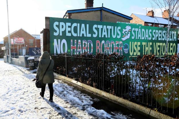 Una joven camina junto a un cartel que pide en Belfast un estatus especial para Ulster. :: Paul FAITH / afp