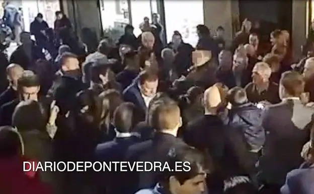 Momento en el que Rajoy (en el centro de la imagen) recibe el puñetazo.