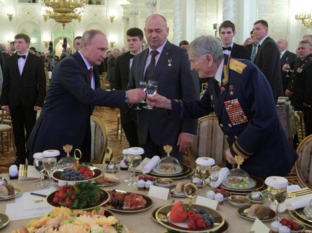 Homenaje. Putin brinda en el Kremlin con un veterano de la II Guerra Mundial en el Día de los Héroes de la Patria. :: Alexéi Druzhinin / REUTERS 