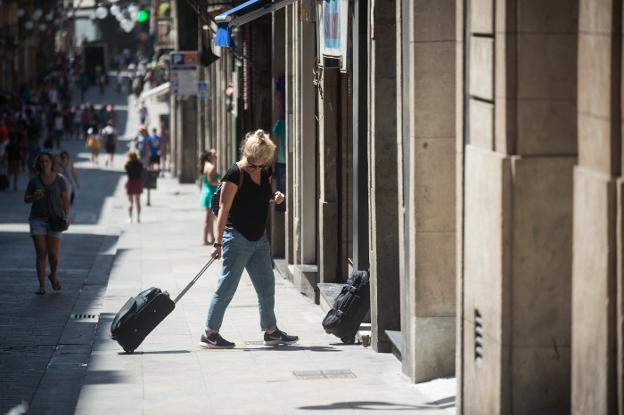 Una turista con su maleta antes de acceder a un piso turístico en el centro de Barcelona. :: I. baucells