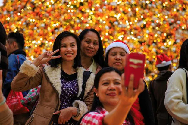 Mujeres filipinas se hacen un selfi en la excolonia británica. :: afp