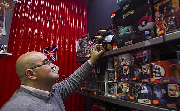 Miguel Ángel Díaz coloca unos artículos de ‘merchandising’ en la tienda del Soho de la empresa malagueña 