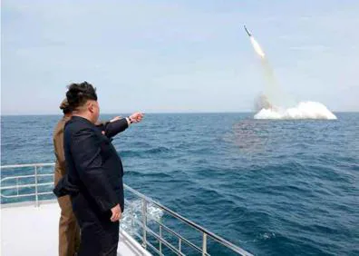 Imagen secundaria 1 - Arriba, Trump en su escritorio del Despacho Oval de la Casa Blanca. Abajo, a la derecha, Kim Jong-un durante el lanzamiento de un misil. A la izquierda, Putin, con el militar que lleva la maleta nuclear rusa, ‘Cheget’.