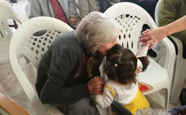 Una abuela besa a una niña