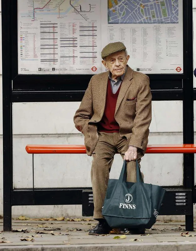 Un hombre espera al autobús en Londres. :: L. MacGregor / Reuters
