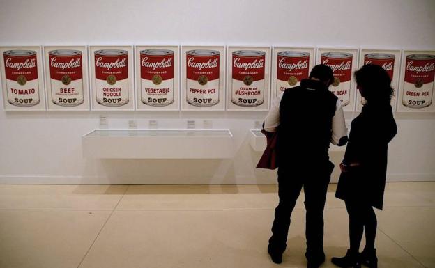 Imagen principal - Dos personas ante la obra ‘Campbell Soup’ (1968). Varias versiones de la obra ‘Vaca’. ‘Single Elvis’ (1963), otra de las piezas de la muestra ‘Andy Warhol. El arte mecánico’, presentada ayer en CaixaForum Madrid. 