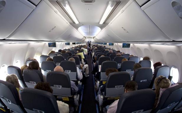 Vista interior de la clase turista de un avión de pasajeros. 