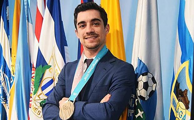 Fernández, con su medalla delante de la bandera del Málaga. 