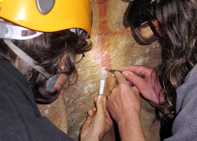 Imagen secundaria 1 - Detalle de una de las pinturas.Dos investigadores junto a unas pinturas. Varias cerámicas complementarias a la investigación.