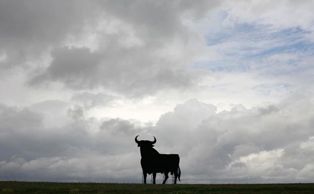 La figura del toro de Osborne se recorta contra el horizonte en una llanura de Fuente de Cantos (Badajoz).