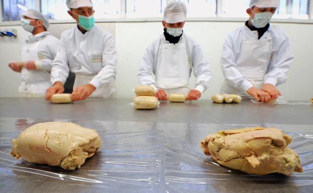 Varios trabajadores, preparan lotes de paté.