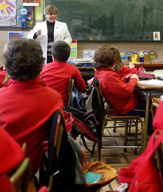 Una maestra da clase en un aula de Primaria de un colegio español. :: AFP