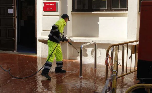 Un funcionario limpia una calle con agua a presión. :: avelino gómez