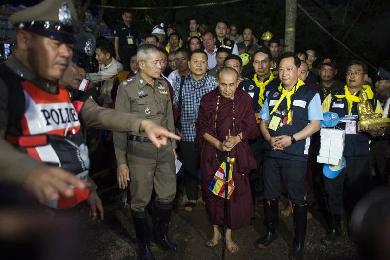 El famoso monje budista Kruba Boonchum reza con familiares de los niños desaparecidos en la cueva Tham Luang durante una operación de rescate para 12 niños y su entrenador atrapado en la cueva en el parque Khun Nam Nang Non Forest en el distrito Mae Sai de Chiang Provincia de Rai el 4 de julio de 2018. Rescatistas tailandeses prometieron adoptar un enfoque "sin riesgo" para liberar a 12 niños y su entrenador de fútbol de una cueva inundada, ya que el 4 de julio apareció un nuevo video que muestra al equipo de buen humor tras su sorprendente descubrimiento nueve días después de desaparecer. 