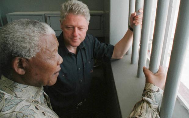 Nelson Mandela muestra su celda a Bill Clinton. 