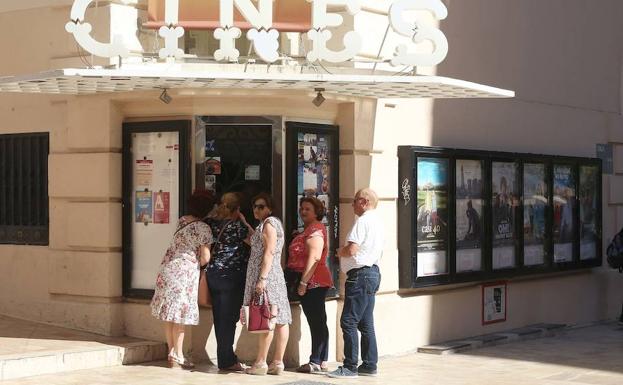 Unos espectadores, ayer, ante la taquilla del cine Albéniz, que bajará las entradas por la reducción del IVA.