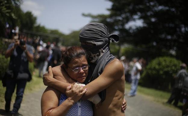 Un estudiante abraza a un familiar tras salir de la parroquia Divina Misericordia. 