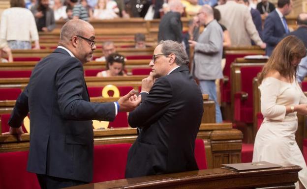 El presidente de la Generalitat de Cataluña, Quim Torra, dialoga con el conseller de Interior, Miquel Buch.