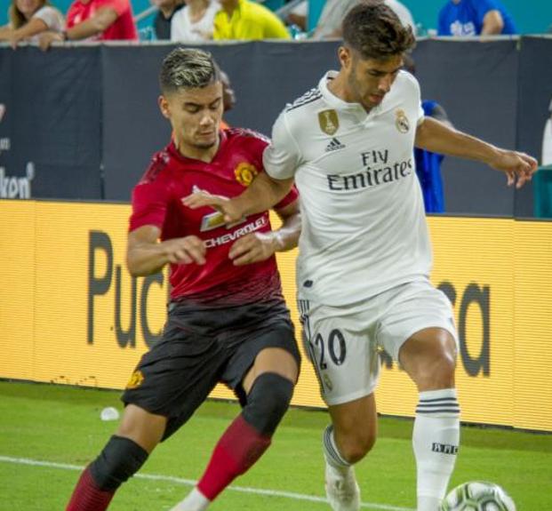 Marco Asensio pugna con Andreas Pereira durante el partido que midió al Madrid con el Manchester United en la International Champions Cup. 