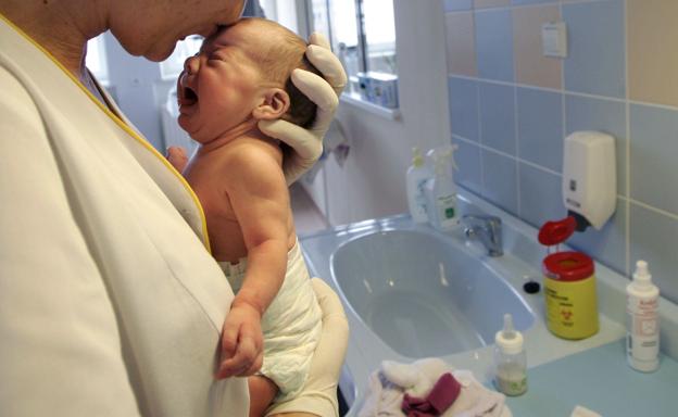 Una enfermera besa a un recién nacido (archivo).