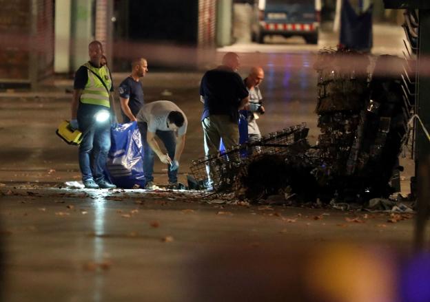 Agentes policiales recogen pruebas en La Rambla, Barcelona, la noche de los atentados del 17 de agosto del año pasado. :: Sergio Perez / reuters