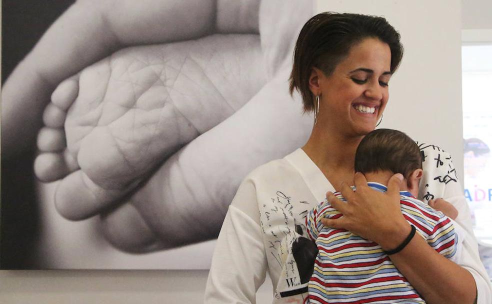 Ana Belén, de 28 años, sonríe en la sala de espera de Red Madre con su pequeño A., de dos meses, en brazos