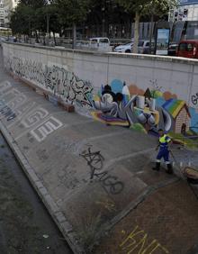Imagen secundaria 2 - Arriba, detalle de las pintadas. Abajo, cristales rotos en el paseo con pérgolas y aspecto de las lenguas de agua que suben desde el CAC hasta el puente de Tetuán. :