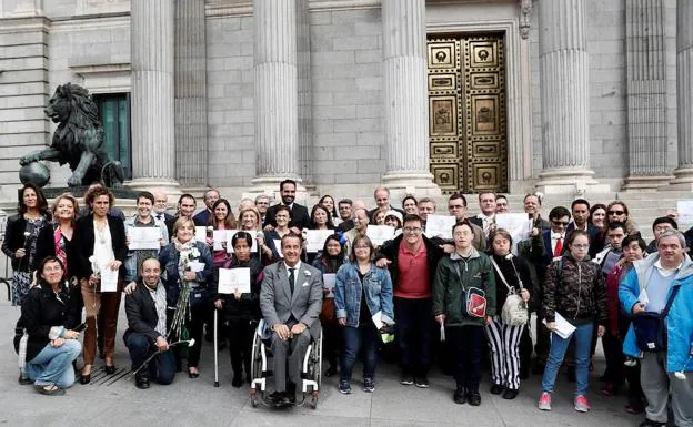 El diputado del PP Ignacio Tremiño posa junto a miembros de diferentes colectivos a las puertas del Congreso de los Diputados.