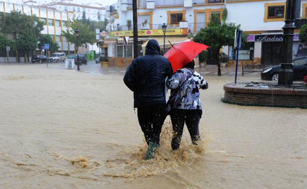 Una pareja trata de cruzar la avenida Juan Carlos I. 