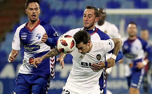 Santi Mina disputa un balón durante el partido.