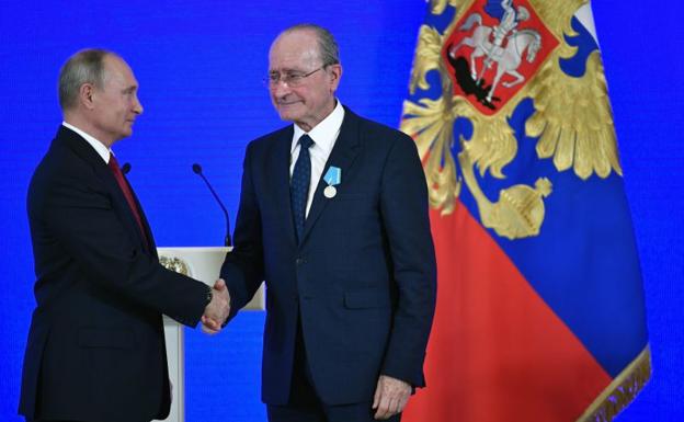 El alcalde de Málaga y el presidente ruso, Vladimir Putin, se dan la mano tras recibir la medalla.